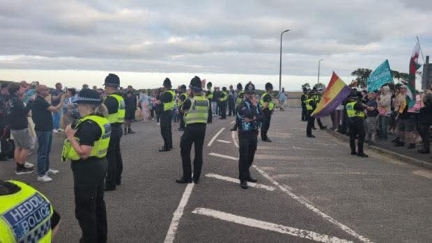 Photo of police, protesters and counter-protesters close to Holiday Inn, Cardiff Airport on the 8th of August 2025.